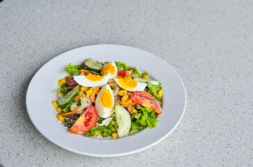 Close up view of egg salad on the white plate. cruttong. mix salad. boiled egg. dressing. vegetables. high angle, above. granite table on the background. isolated. copy space, empty, free, negative.