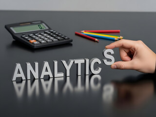 Hand placing a letter to complete 'ANALYTICS' with metallic letters on a dark desk, symbolizing strategic data analysis, business intelligence, and informed corporate decisions