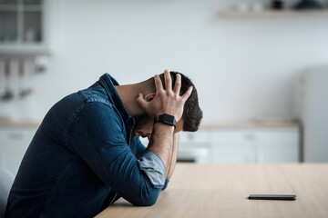 Stress, problems, depression at home, unemployment, loneliness and bad feeling. Sad young man holds...