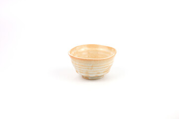 An elegant handmade ceramic bowl with a rustic texture and natural cream glaze, featuring concentric rings from the pottery wheel. Japanese Chawan style is perfectly isolated on white background.