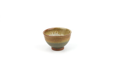 An artisan ceramic bowl with a striking earth tone layered glaze (brown, green, and beige), a rustic texture and natural rim isolated on a white background. Tea ceremonies, and home decor styling.