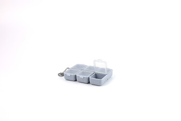 A compact plastic pill box with six compartments and transparent lids, attached to a small chain, perfectly isolated on white background. Daily medicine management, vitamins, and portable for travel.