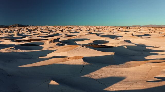 Sweeping across sculpted pumice dunes and wind shaped volcanic terrain under clear blue sky
