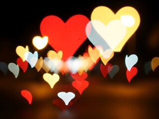 Vibrant colorful hearts floating in dark romantic background