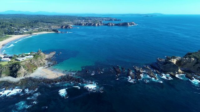 Drone aerial landscape of scenic Rosedale beach and Jimmies Island rocky headland reef with rural town homes and bushland along Malua Bay coastline in South Coast Australia travel tourism and nature