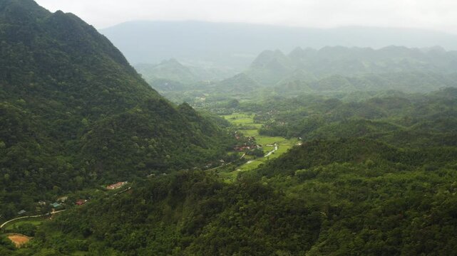The Pu Luong wilderness. Featuring deep green valleys, traditional stilt houses, and mist-covered limestone peaks in a pristine Vietnamese nature reserve.