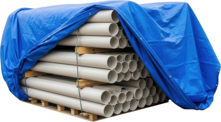 Stack of large diameter grey pipes partially covered with a bright blue protective tarp resting on wooden pallets in a storage area construction materials plumbing drainage water supply