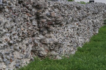 Rough stone wall texture made of natural rocks and aged masonry. Detailed surface with irregular stones, weathered appearance and neutral color tones.