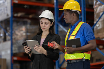 Professional warehouse staff using digital tablet, barcode scanner for inventory management, teamwork and communication, representing modern logistics, supply chain operations.