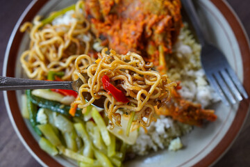 Bebek rica spicy duck dish with rich chili seasoning, served with steamed rice, stir-fried noodles, and vegetables, bold Indonesian flavor with rustic homestyle presentation