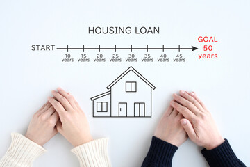 50年の住宅ローンに関して考える若い夫婦の手元