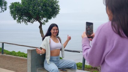 Young friends creating social media content in a park overlooking the sea
