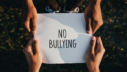 No Bullying Sign Held by Hands Outdoors.