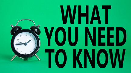 What You need to Know symbol. Wooden blocks with words What You need to Know. Beautiful green background with alarm clock. Business and What You need to Know. Copy space.