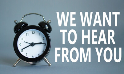 We want to hear from you symbol. Wooden blocks with words We want to hear from you. Beautiful grey background with alarm clock. Business and We want to hear from you. Copy space.