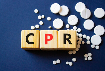 CPR symbol. Wooden cubes with words CPR Cardiopulmonary Resuscitation. Beautiful deep blue background. Healthcare and Cardiopulmonary Resuscitation concept. Copy space.