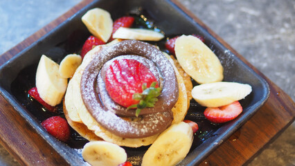 Delicious pancakes with fruits served on a square plate