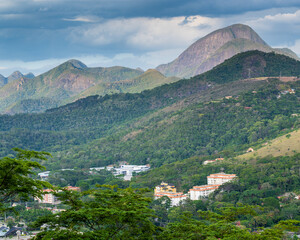 Fototapeta premium A mix of Atlatntic Forest, housing development and a mountain in the background in Petropolis, Rio de Janeiro, Itaipava, showing the use of the Atlantic Forest