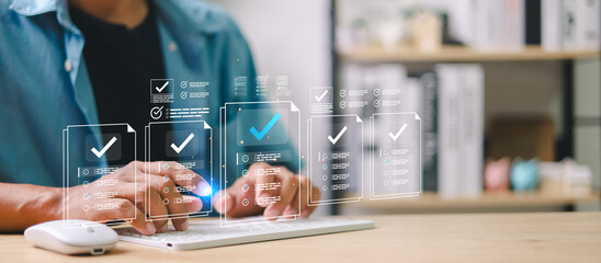 Businessman using digital checklist interface on tablet and laptop. Concept of online document verification, approval workflow, electronic forms, task management, and digitalization.