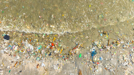 Plastic waste, plastic cups at the beach. Concept of environmental problems and saving the plane	