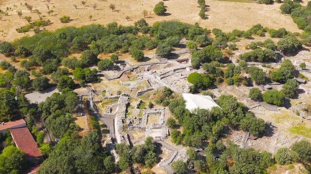Tevfikiye, Turkey. Aerial view of the stone ramp and main gate of Troy II, with surrounding vegetation and trees on the mound of Hisarlik. Aerial view, MasterShots, Spiral forward