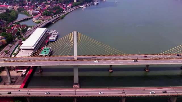 Vehicles moving on cable bridge (Atal setu) with Boat Cruises area and river at goa. day time, trucking shot, drone shot, 4k.