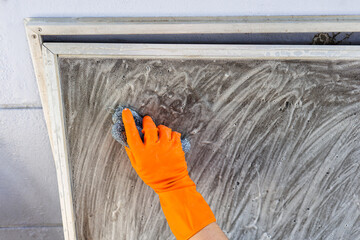 Hand Cleaning Window Screen with Steel Wool at Home
