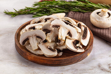 Raw champignon slices on the board