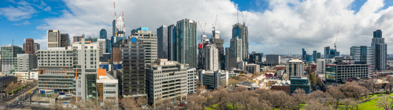 Aerial panorama view of a congested city skyline with construction cranes