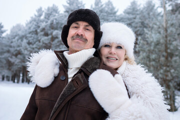 Happy Snowy Couple, Smiling Couple With Winter Backdrop, Smiling Couple Dressed Warmly With Snowy Pine Background, Cheerful Pair Posing Near Icy Pine Trees With Cozy Clothing And Soft Sunshine