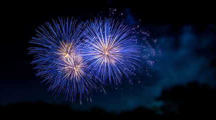 Bright blue fireworks explode against a dark night sky, creating a festive and vibrant display with bursts of light and color
