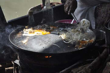 Street food frying pan egg bean sprout river Asian street food frying pan egg bean sprout river Asian vendor cooking delicious