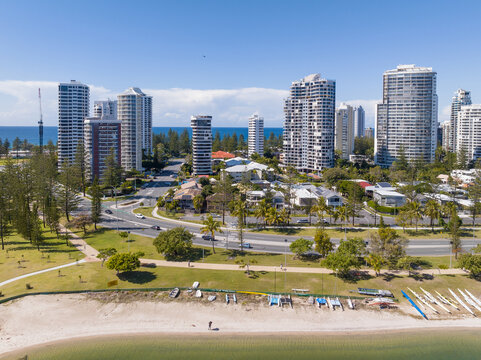 Aerial view of a beach and esplanade in front of highrise apartment buildings in a coastal city