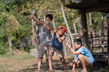 Happy Asian Boys Aiming Slingshots in Rural Countryside.