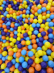 Colorful balls filling the playground pit from a top view
