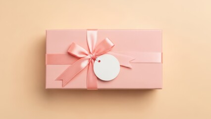 A pink gift box with a ribbon and tag on a beige background