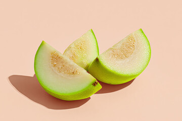 Guava Slices: Vibrant slices of juicy guava, their refreshing green exterior and inviting flesh, are arranged against a warm backdrop, promising a burst of tropical freshness.