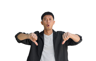 A young Asian man wearing black coat making a displeased gesture showing a thumbs down isolated on a white background. The concept of expressing dislike or opposing opinions