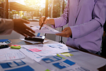 Close up ux developer and ui designer brainstorming about mobile app interface wireframe design on table with customer breif and color code at modern office.Creative digital development agency.