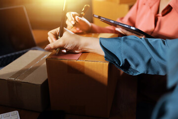 Startup SME small business entrepreneur of freelance Asian woman wearing apron using laptop and box...