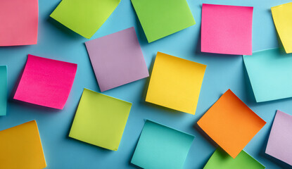 Colorful sticky notes with smooth paper texture arranged on a bright blue background for organization and planning