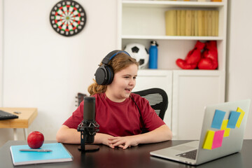 Kid vlogger recording content with a microphone for child blog. Child content creator speaking into microphone for child blog. Kid making media content with studio setup for child blog.