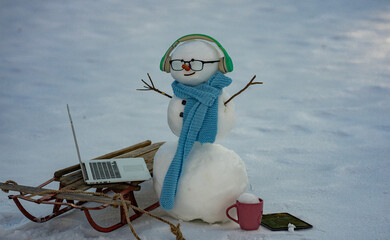 Snowman browsing internet in snowy field. Remote online work winter concept. Snowman doing remote...