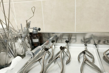 Sterile medical instruments arranged on a metal tray in a clinic, showing surgical tools prepared...