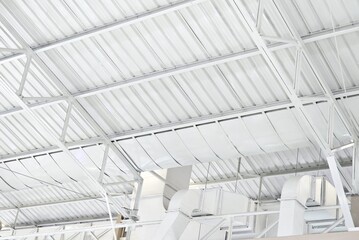 Modern Industrial Building Interior with White Metal Roof Structure and Ventilation System.