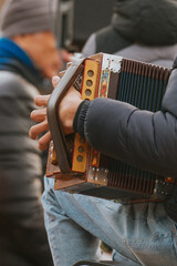 Person playing folk accordion music instrument outdoors