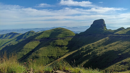Naklejka premium Dramatic mountain landscape of the Drakensberg Mountains with steep cliffs and rolling green valleys in South Africa