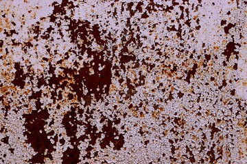 Background, texture of cracked old paint residue on a rusty metal sheet