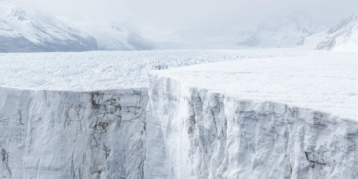 Glacier edge in a snowy landscape with mountains and fog during the daytime at a cold location - Powered by Adobe