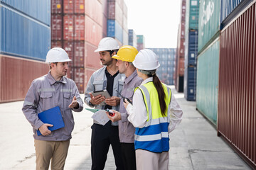 Engineer and worker team working in logistic terminal of container cargo, Diverse construction team in safety gear outdoors